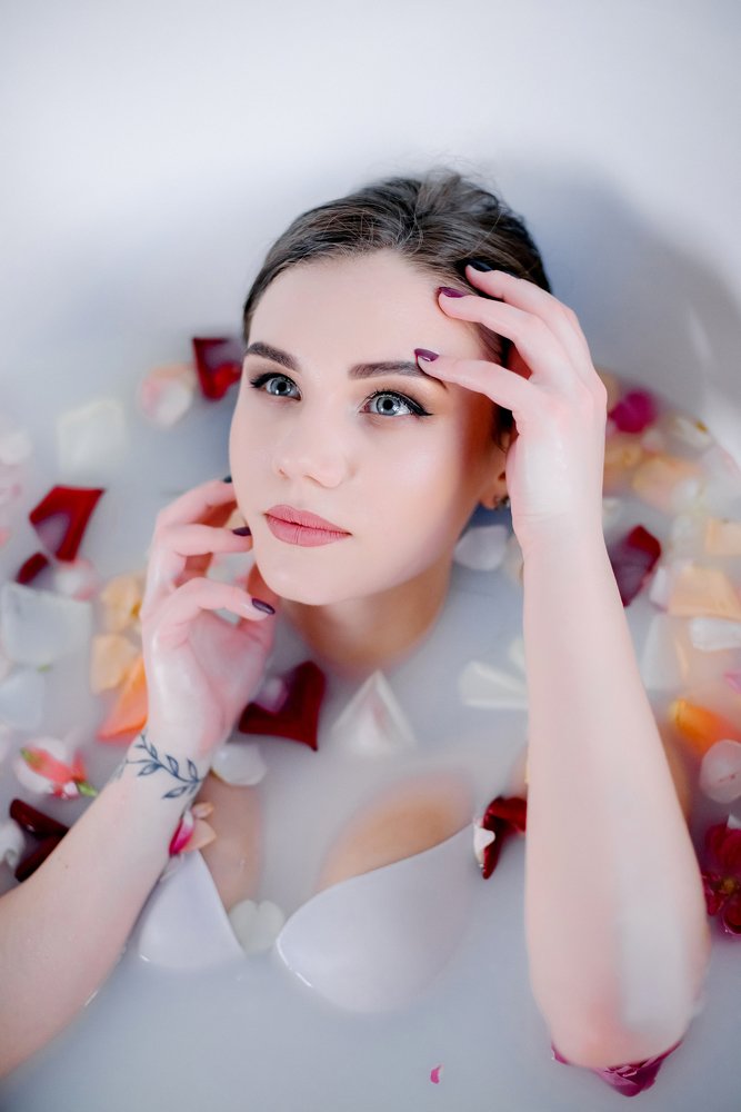 Девушка в ванной с молоком и цветами