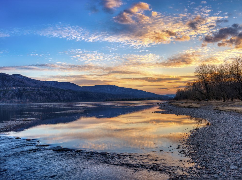 Догорает закат над рекою.