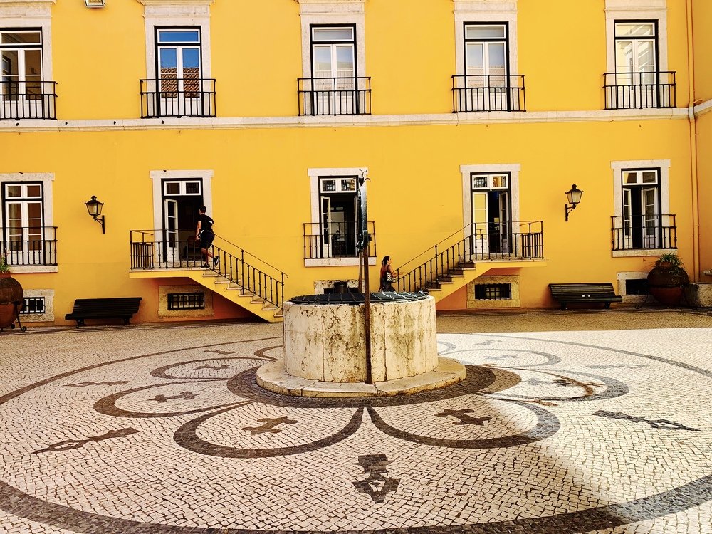 Windows on yellow and Portuguese sidewalk