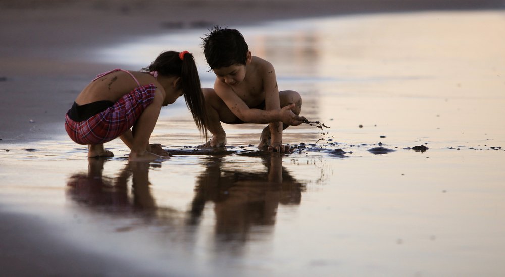 siblings playing on the beach