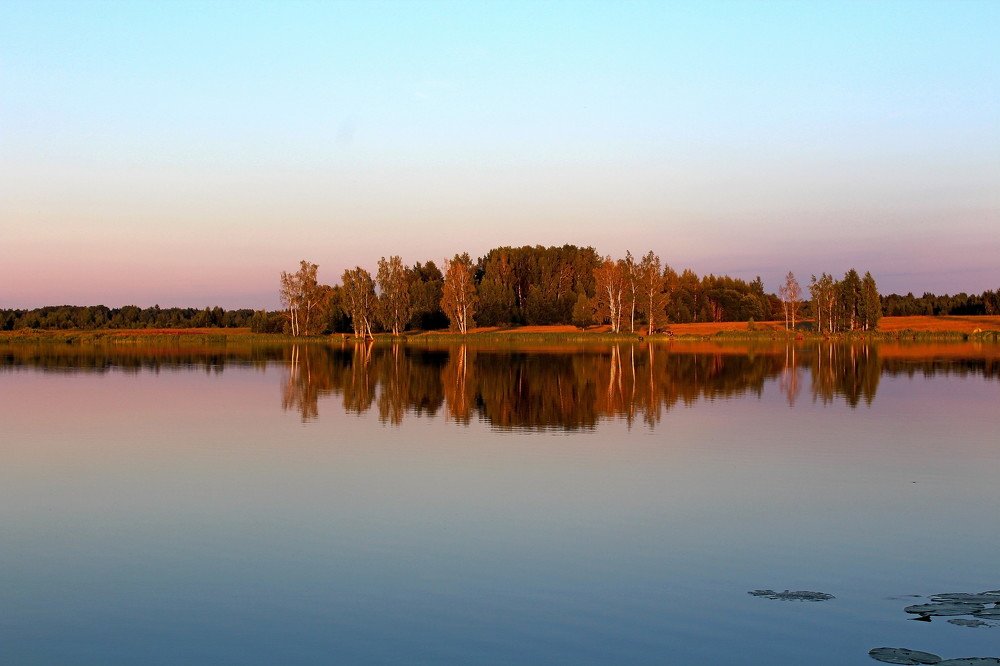 Water in calm weather in the rays of the setting sun.