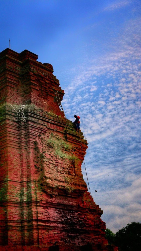 cleaning the roof of the temple of Brahu