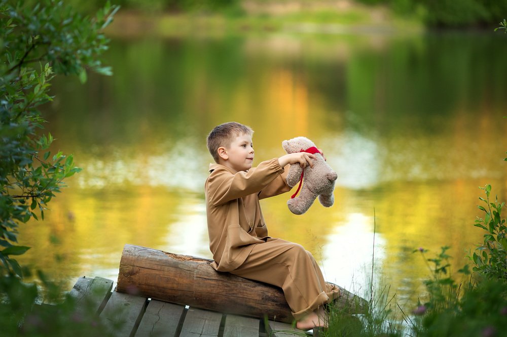 Мальчик играет с мишкой