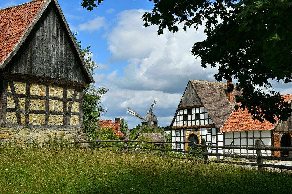 Rustic summer landscape. Beautiful village photo, old houses, green grass, blue sky.