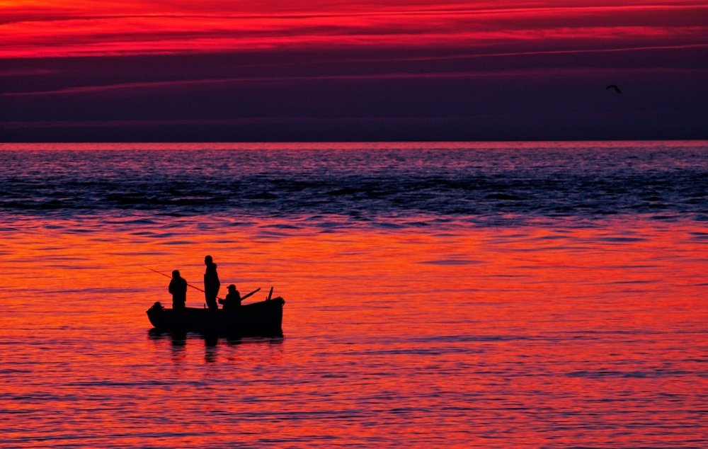 Fishing in the black sea at the sunset