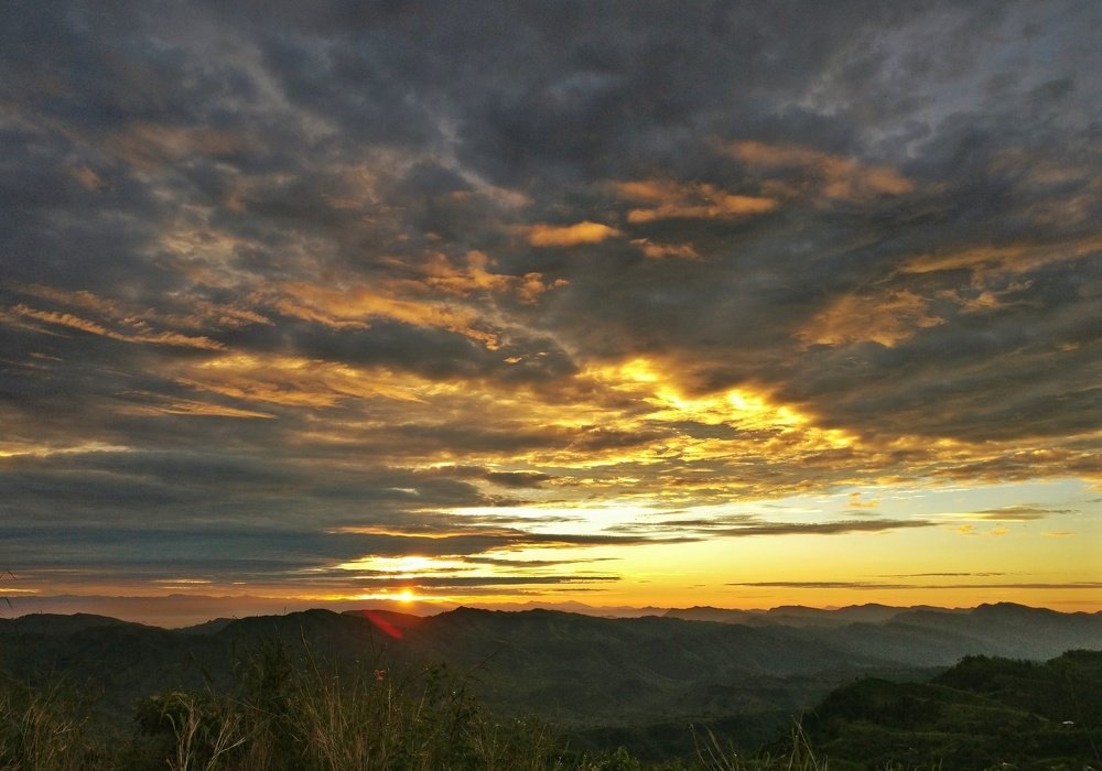 Sunrise behind a hill