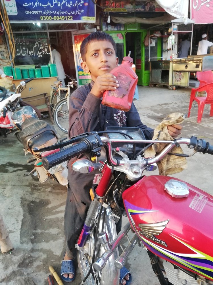 CHILD WORKING AT MOTORCYCLE SHOP