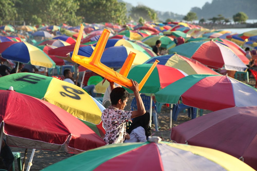 lift a yellow table between colorful umbrellas