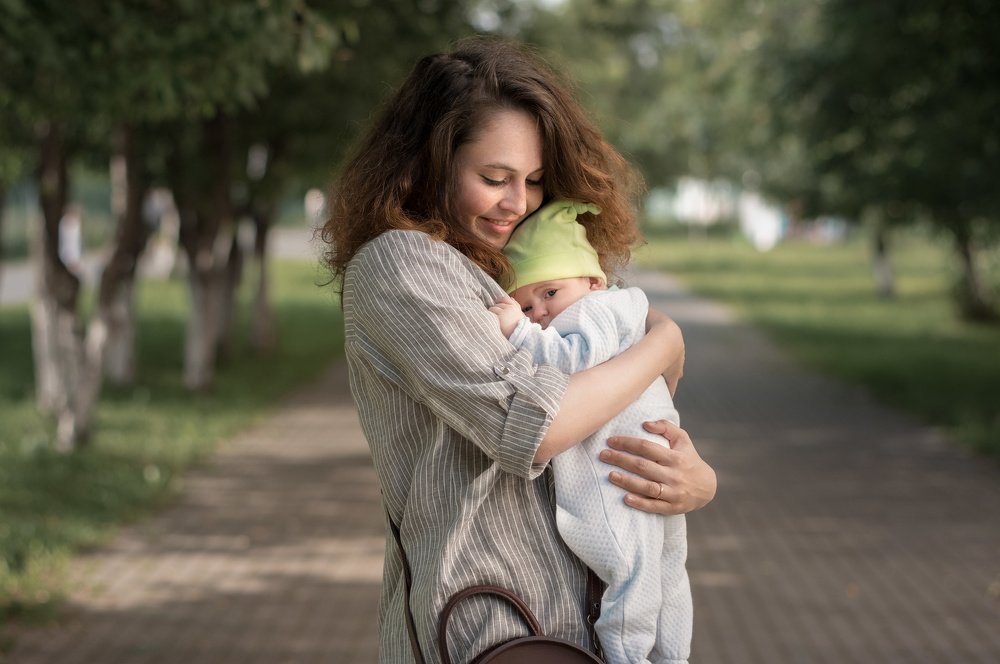 Мама с ребенком на Крымской алее в тени ив и лип