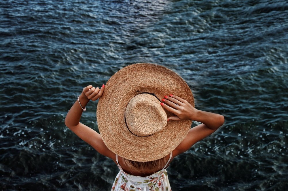 Девушка с шляпой на море