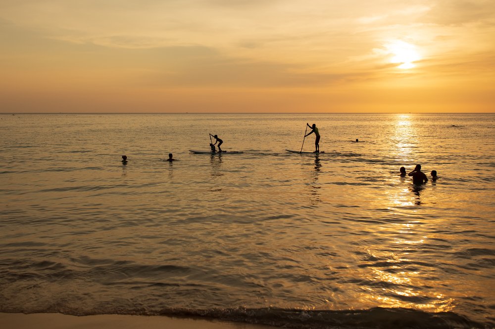 Мальчики на досках на фоне заката
