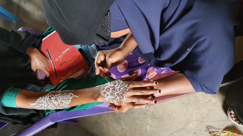 Young ladies learning how to apply hinna