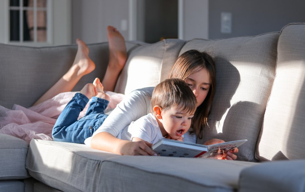 Sister and brother reading a book together
