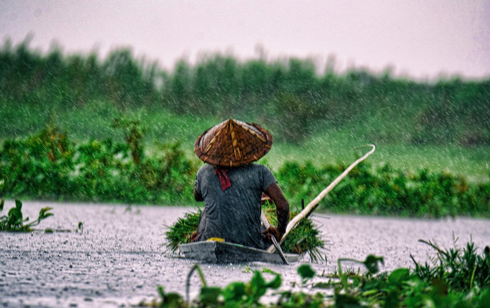Boatman sailing on a rainy day