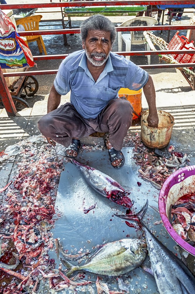 Iranian man cleans tuna at a fish market in Bandar Abbas