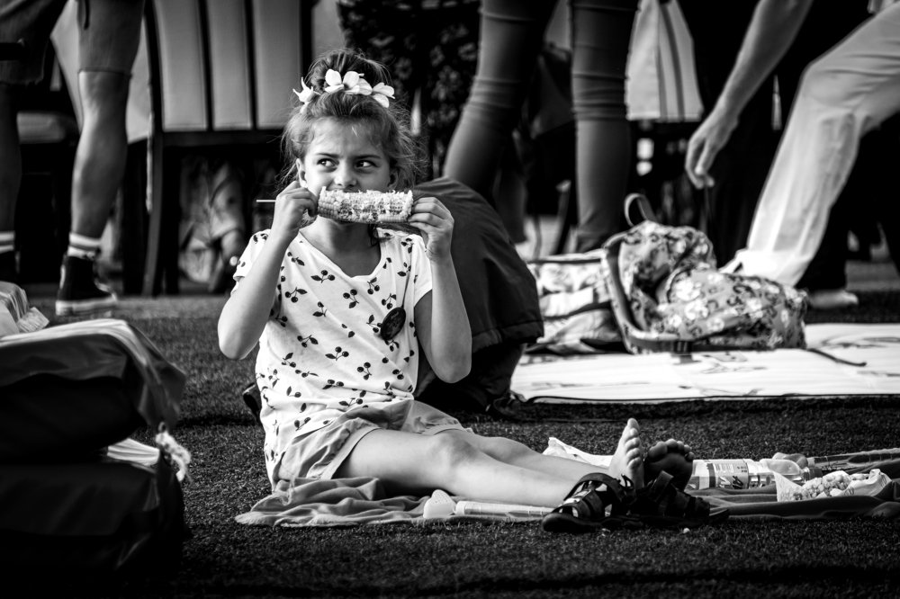 Девочка, кушающая кукурузу