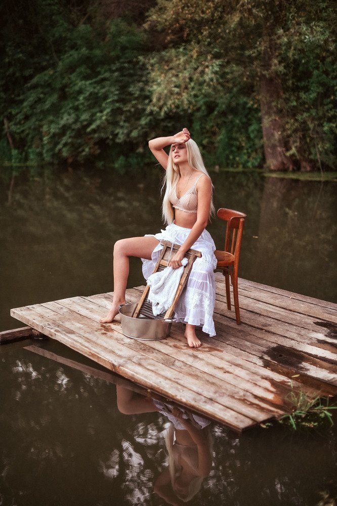 Девушка стирает белье на реке