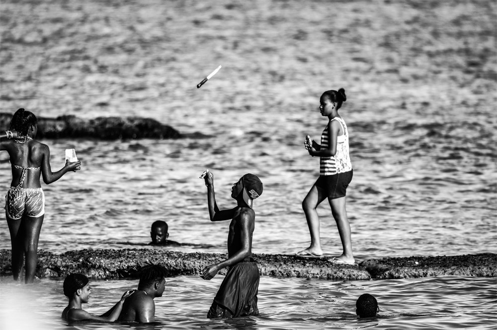Boy playing with a knife on the beach (Juan Dolio, Dominican Republic)