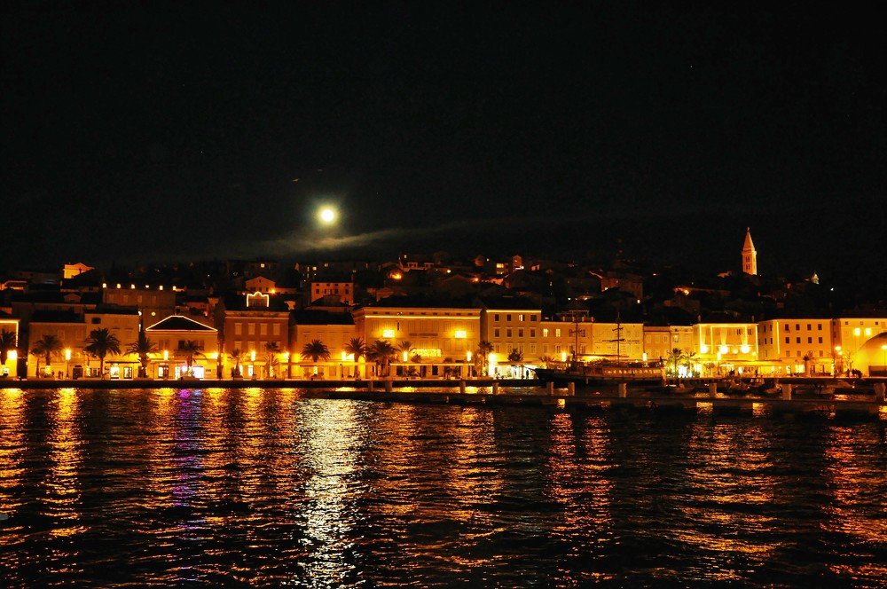 Night light in Losinj lagoon with moon and cityscape