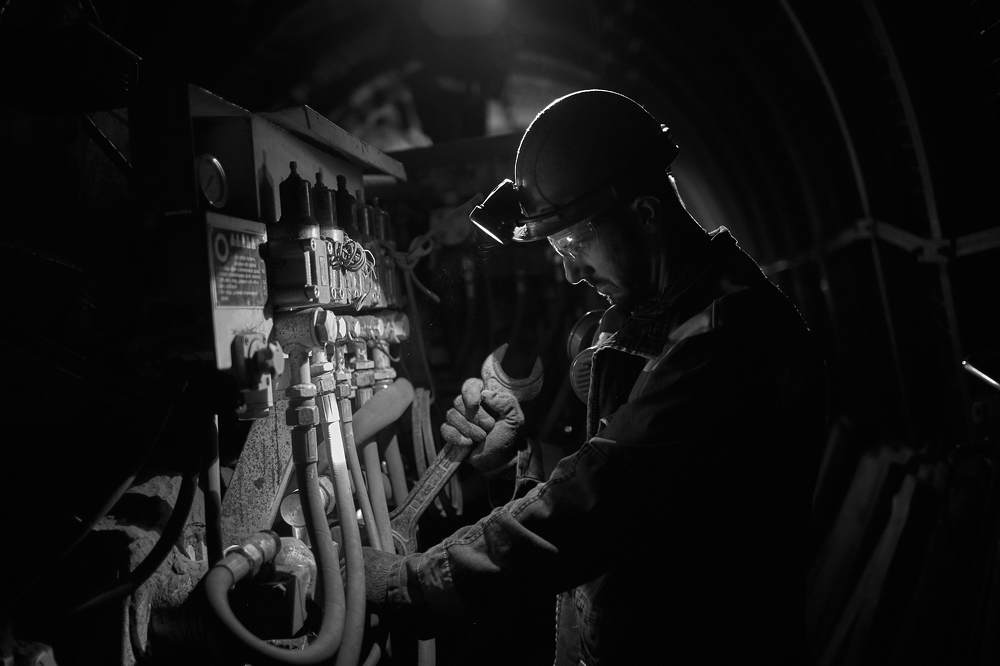 Комбайнер чинит комбайн в шахте