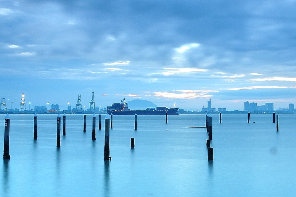 Sunrise photo nearby of jetty in Penang island with port and vessel as background