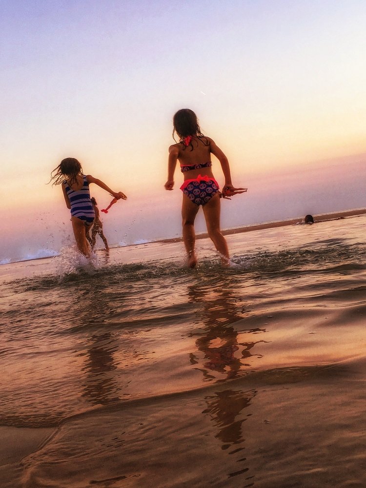 Sisters playing at sea with their dolls...