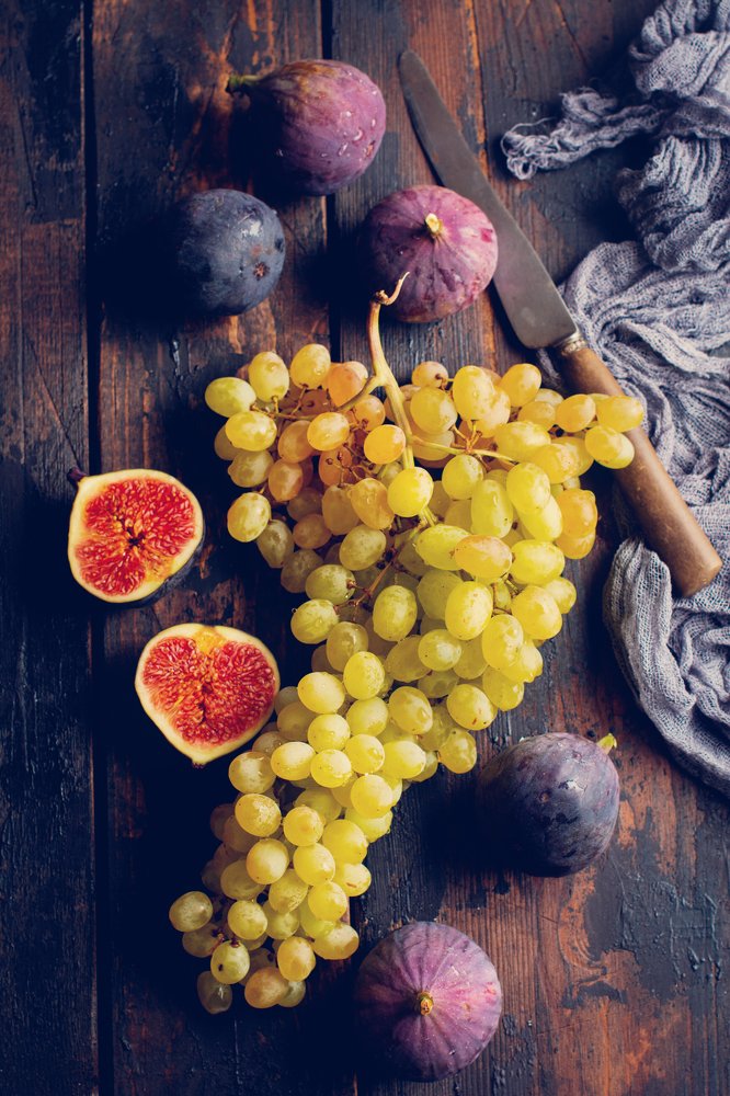 Fresh grapes and figs on an old wooden background.
