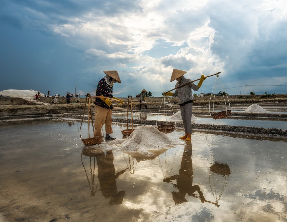 Harvesting sea salt before the rain