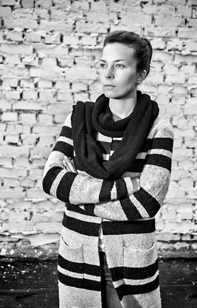 Портрет девушки на фоне кирпичной стены.