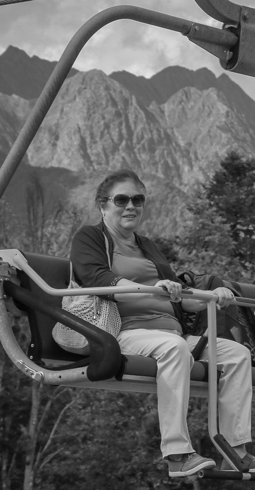 Женщина на открытом кресле канатной дороги в Красной Поляне.