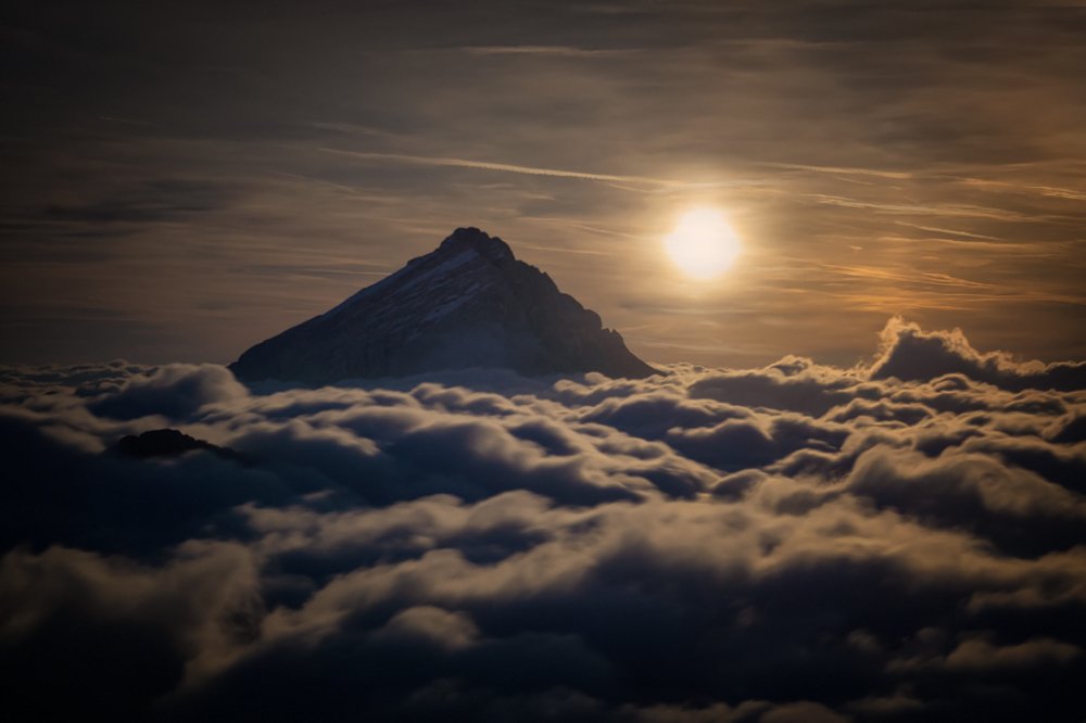 Monn behind mountain.