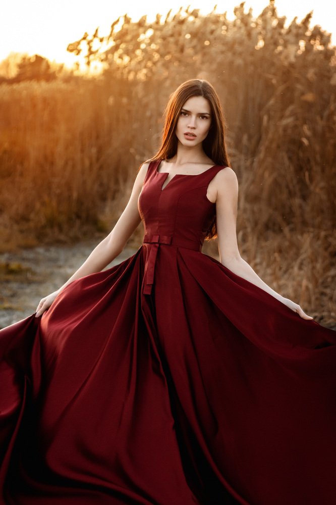 Девушка в красном платье на фоне заката.