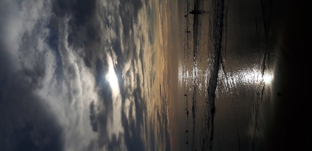 The Sun's light peeping behind the clouds.