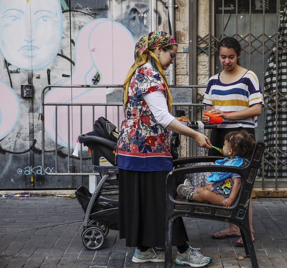 На скамейках.