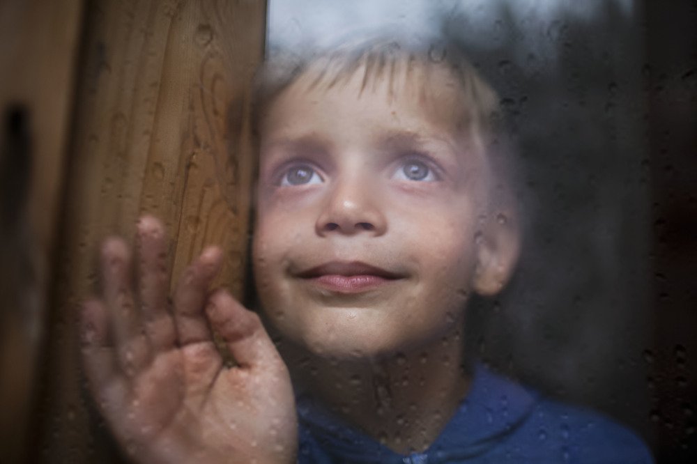 За стеклом.