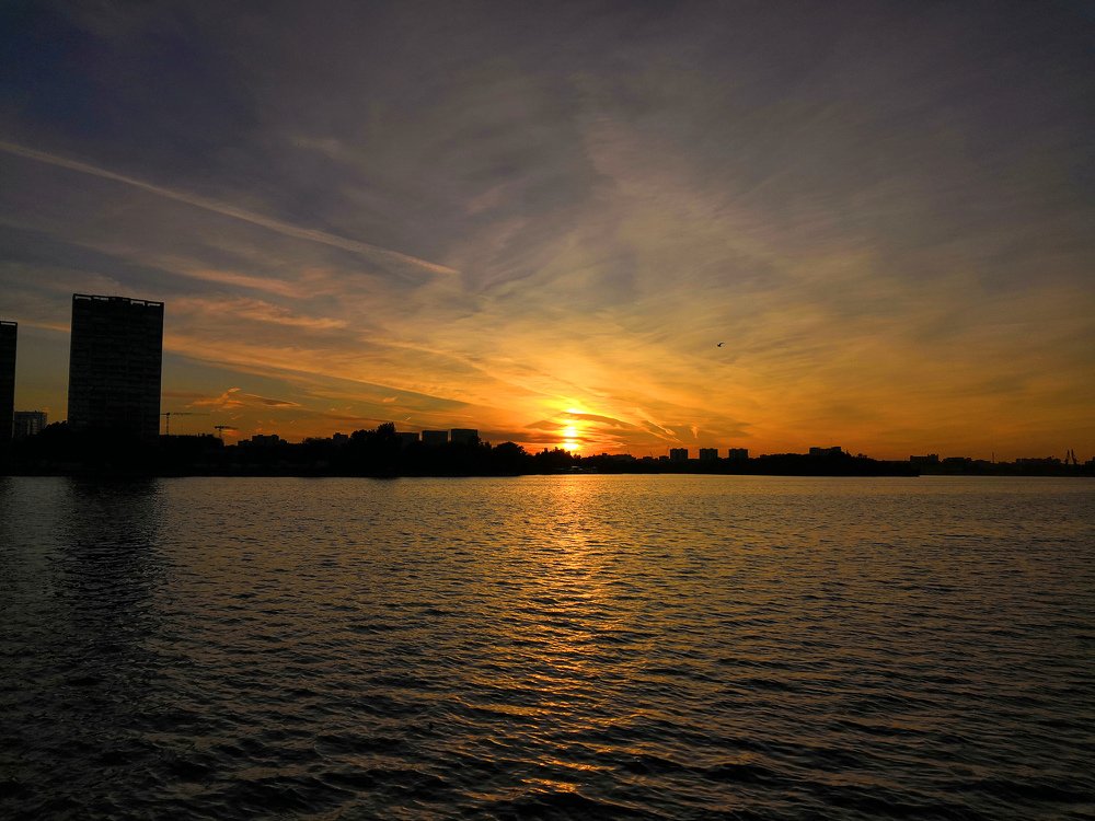 Силуэт города в закатных лучах солнца.