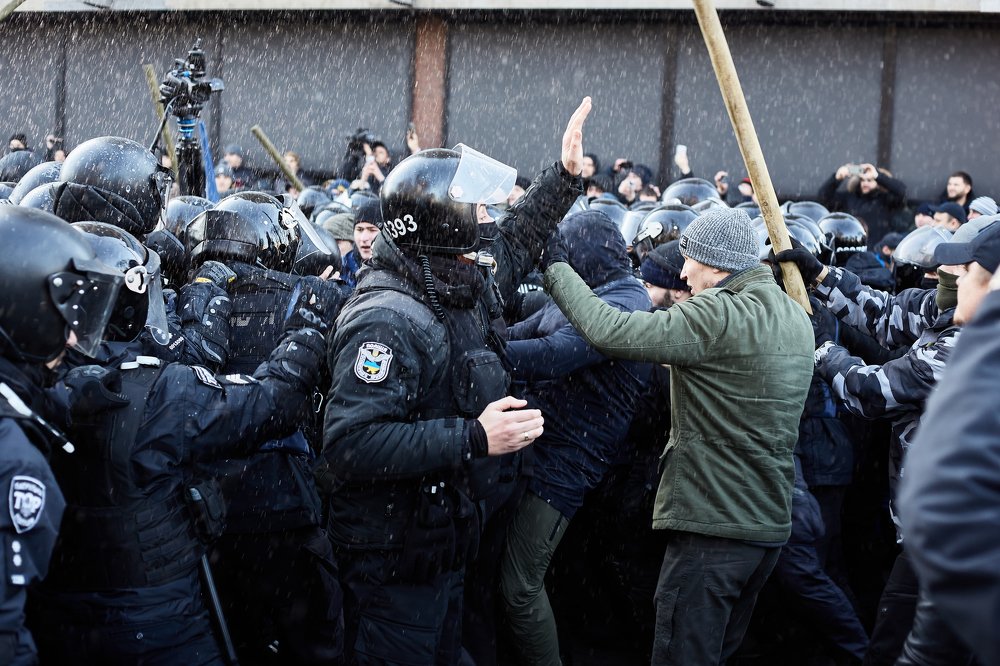 The policeman calls the protesters to calm down.