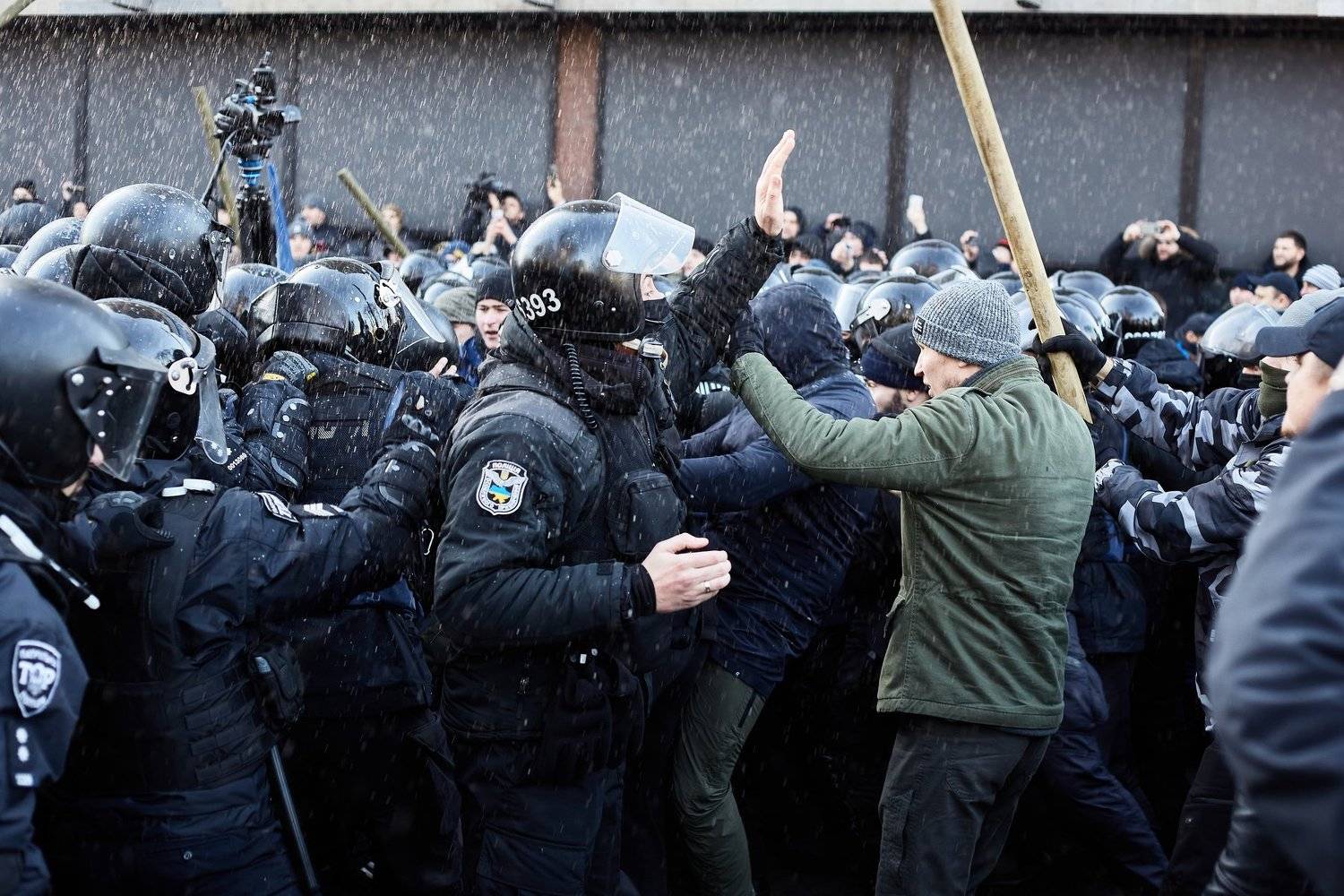 The policeman calls the protesters to calm down.