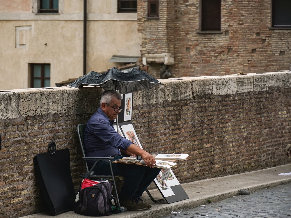 An artist is on the street of Rome.