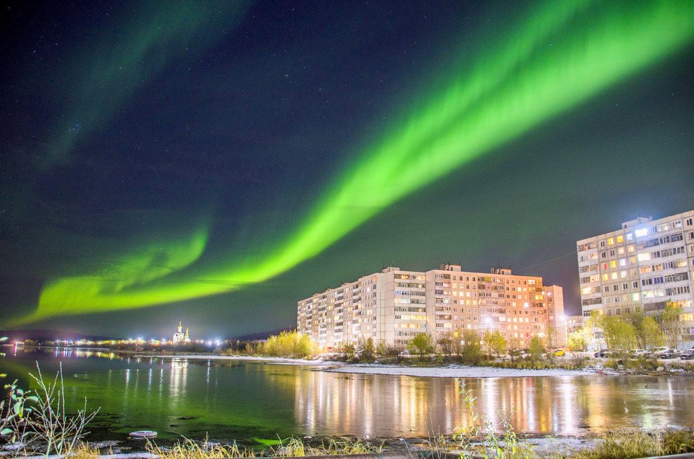 Лента сияния над вечерним городом.