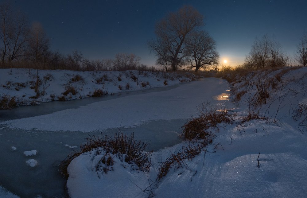 Moonrise under frozen river