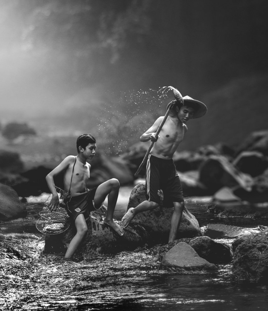 Two boys hunt fish in the river