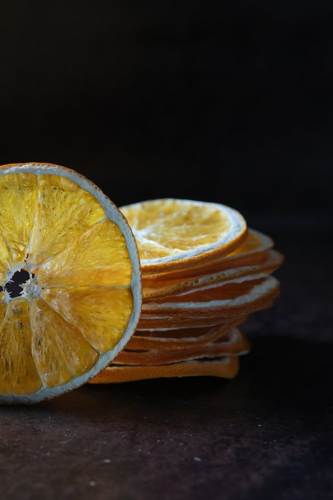 Половинка оранжевого апельсина на темном фоне