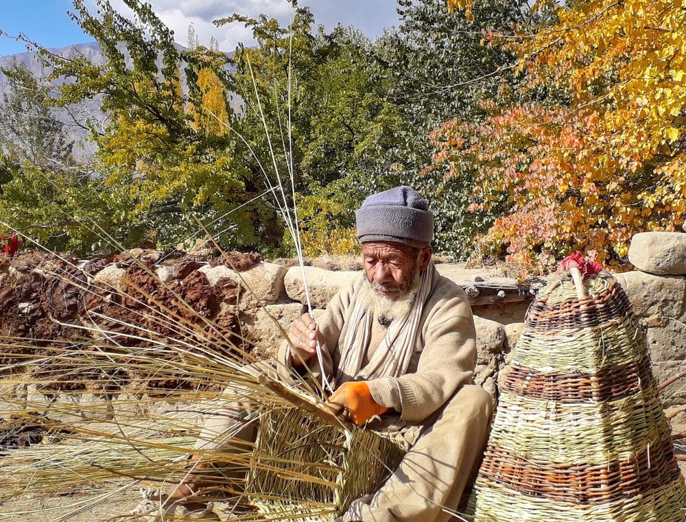 A man is making wooden basket on his roof.