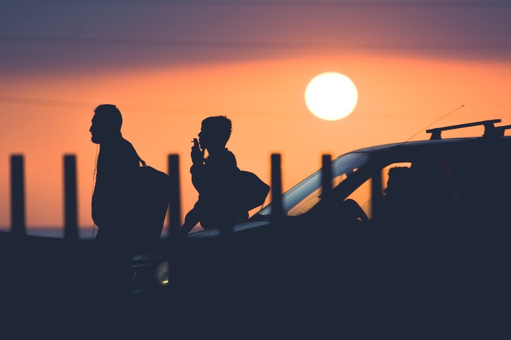 Silhouettes at sunset walking on the street