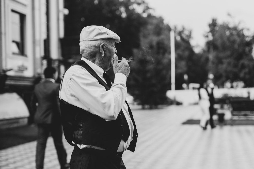 The old man smokes a cigarette, looks into the distance and thinks about the past.