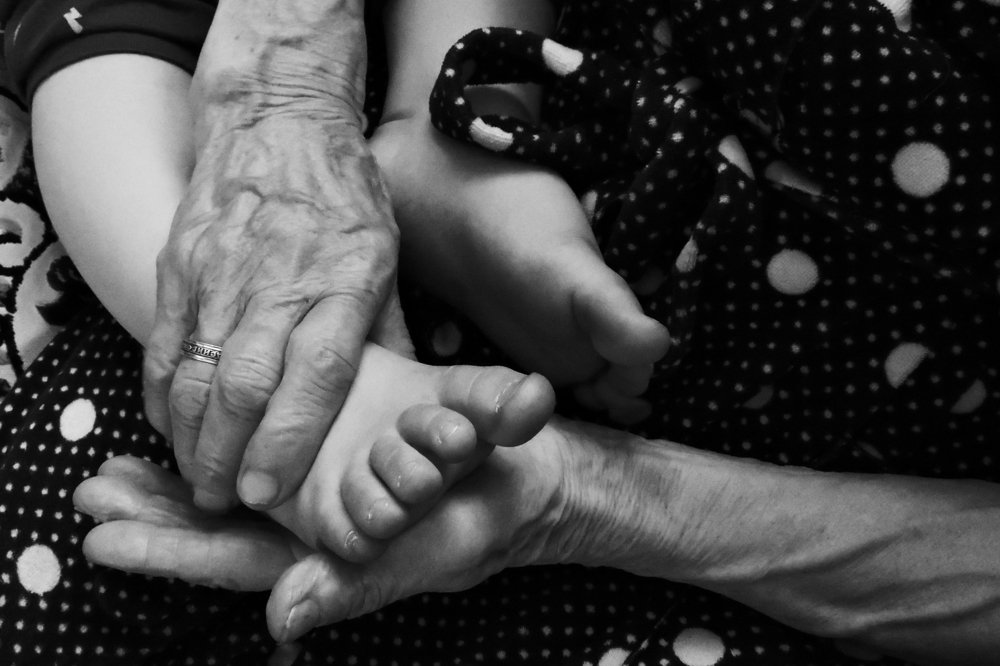 Ножки правнука в руках прабабушки