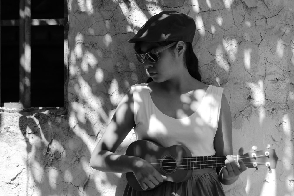 Practicando ukulele en la sombra