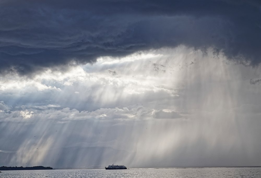 crossing Leman lake toward Geneva under rain and clouds