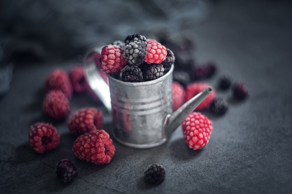 Raspberries and blackberries in tin can